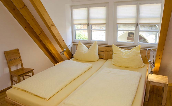 Schlafzimmer mit Doppelbett und Kleiderschrank, alles aus Massivholz - Ferienwohnung Idig, Weingut Thomas Steigelmann, Gimmeldingen (Pfalz), Neustadt / Weinstr.