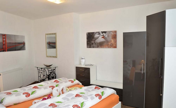 Schlafzimmer mit Doppelbett und Kleiderschrank - Ferienwohnung Palatia, Hof Rebenblüte, Weindorf Gimmeldingen, Neustadt / Weinstr. (Pfalz)