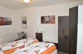 Schlafzimmer mit Doppelbett und Kleiderschrank - Ferienwohnung Palatia, Hof Rebenblüte, Weindorf Gimmeldingen, Neustadt / Weinstr. (Pfalz)